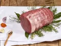 Un añojo ternera, parte de la pierna, listo para asar con hierbas aromáticas, cebolla, zanahoria y especias.