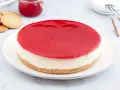 Deliciosa tarta de queso Philadelphia con cobertura roja brillante, lista para disfrutar.