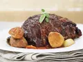 Un jugoso asado de ternera, cocinado a la perfección, servido con castañas glaseadas y hierbas frescas. ¡Así es que es la ternera!