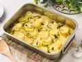 Patatas panaderas recién horneadas, doradas y tiernas, con cebolla y tomillo, listas para servir.