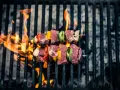 Brochetas de carne y verduras sobre una parrilla con llamas. Así es como se prepara una deliciosa barbacoa.