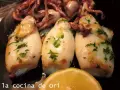 Calamares a la plancha, tiernos y dorados, con perejil fresco y un toque de limón. ¡Un manjar para disfrutar!
