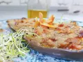 Berenjenas rellenas gratinadas con piñones y brotes frescos, un plato delicioso y nutritivo.