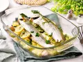 Pescadilla al horno con patatas, limón y ajo, recién salida del horno. Un plato sencillo y delicioso.