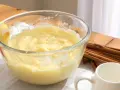 Bol con crema pastelera, huevos, limón y canela. Ingredientes para un postre delicioso.