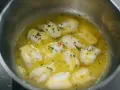 Trozo de bacalao al pil pil burbujeando en una sartén con aceite de oliva, ajo y perejil picado.
