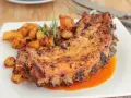 Costillas al horno con patatas doradas y romero fresco. Un plato jugoso y lleno de sabor.