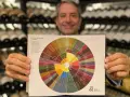 Hombre sonriente muestra rueda de aromas y sabores de vinos, ideal para entender los vinos de Guadalajara.
