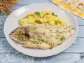Dorada al horno con patatas y perejil, un plato principal delicioso y saludable.
