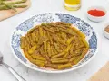 Espárragos esparragados en un plato con diseño azul y blanco, acompañados de pimentón y comino.