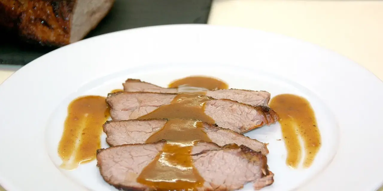 Rabillo de cadera al horno, jugoso y tierno, servido en rodajas con una rica salsa.