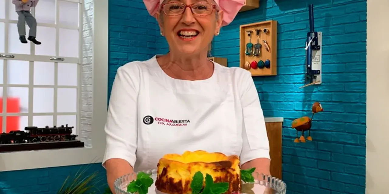 Eva Arguiñano sonríe mostrando una deliciosa tarta de queso casera, decorada con hojas de menta.