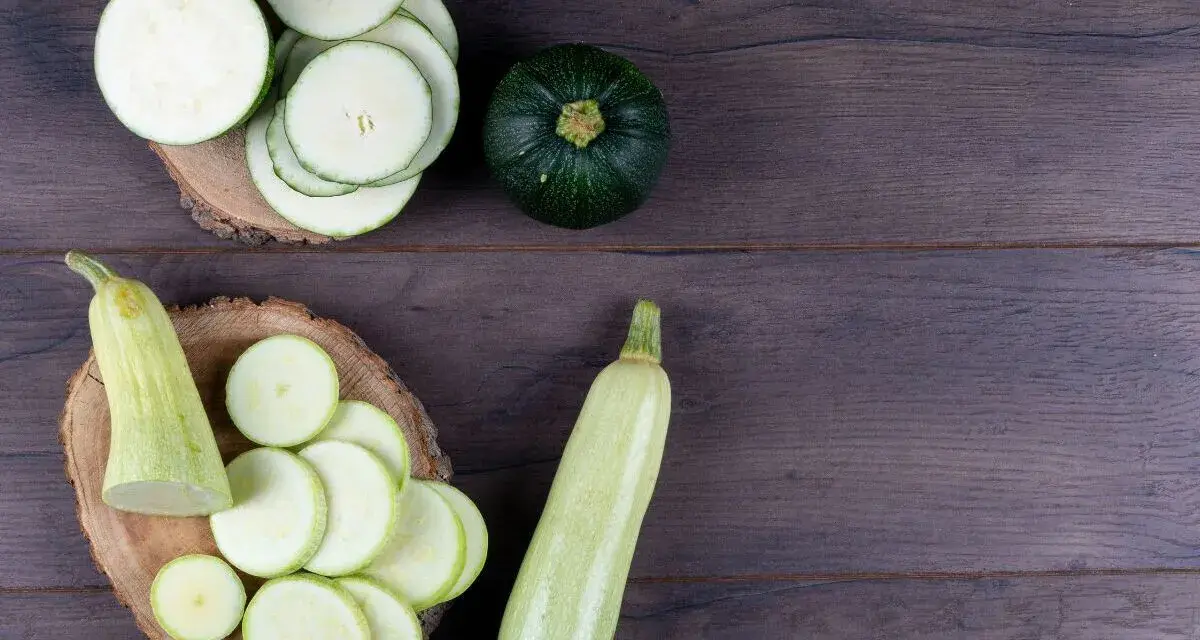 Rodajas de calabacín y calabacines enteros, listos para preparar deliciosas recetas con calabacín.
