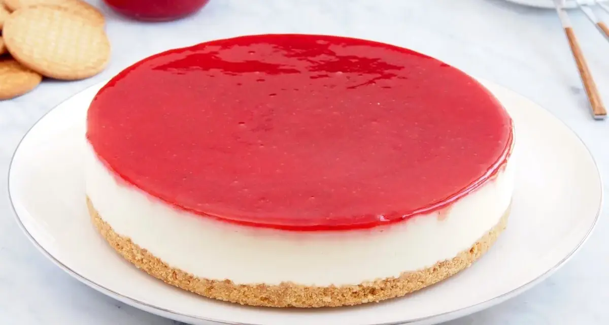 Deliciosa tarta de queso Philadelphia con cobertura roja brillante, lista para disfrutar.