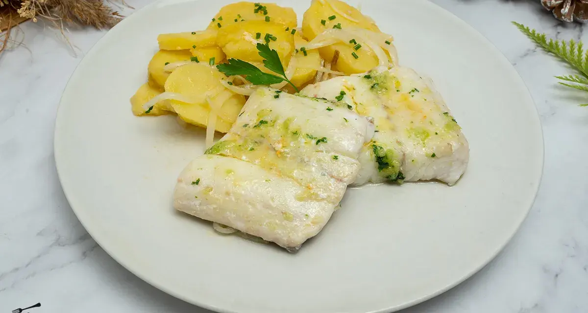 Deliciosa merluza al horno con patatas panadera y perejil picado. Un plato principal ligero y sabroso.