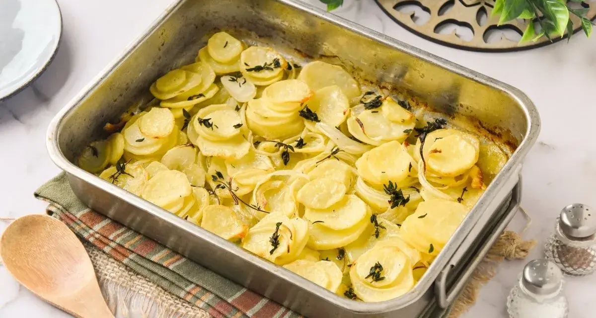 Patatas panaderas recién horneadas, doradas y tiernas, con cebolla y tomillo, listas para servir.