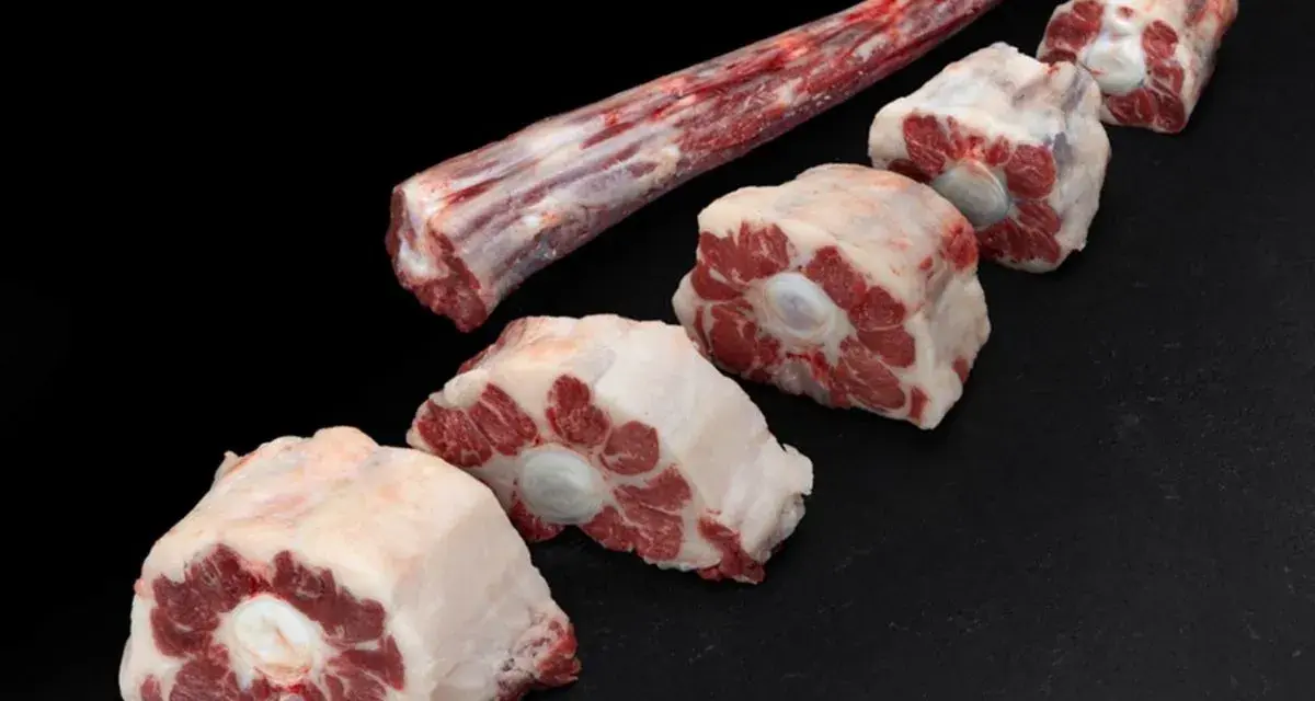 Trozo largo de carne de ternera para guisar y varias porciones cortadas en rodajas, listas para un estofado delicioso.