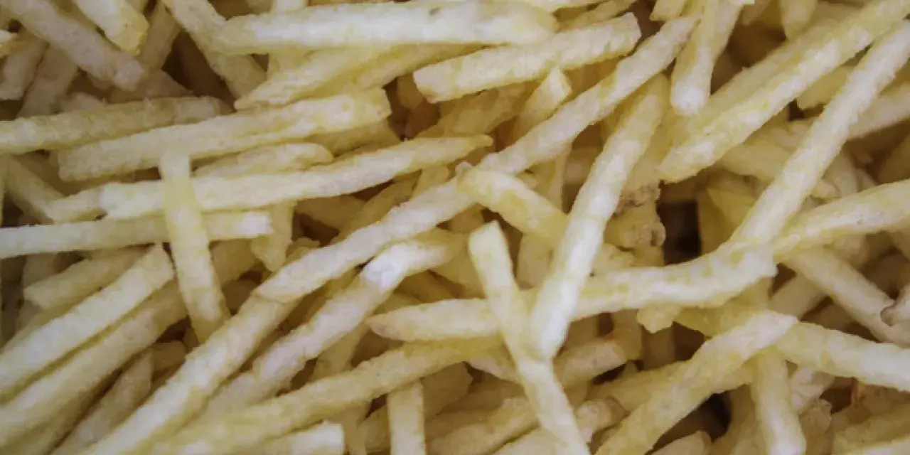 Un montón de patatas paja doradas y crujientes, listas para ser disfrutadas.