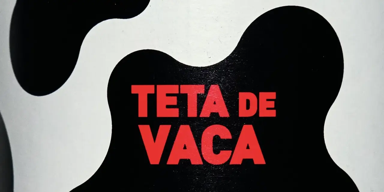 Texto rojo "TETA DE VACA" sobre un fondo blanco y negro con manchas de vaca.