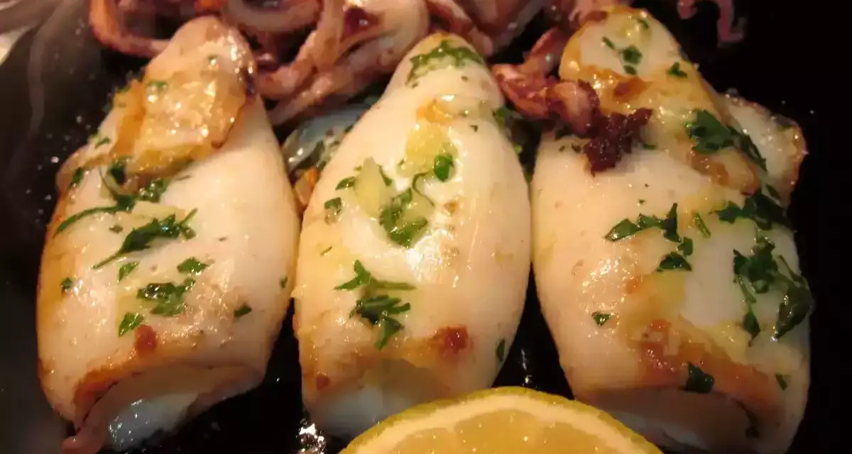 Calamares a la plancha, tiernos y dorados, con perejil fresco y un toque de limón. ¡Un manjar para disfrutar!