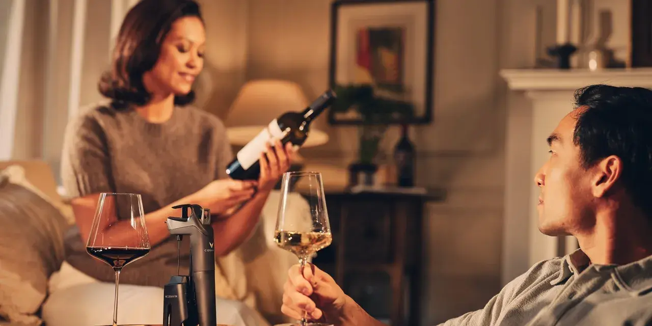 Pareja disfrutando de una copa de vino tinto y blanco. Beber vino es bueno para relajarse y compartir momentos.