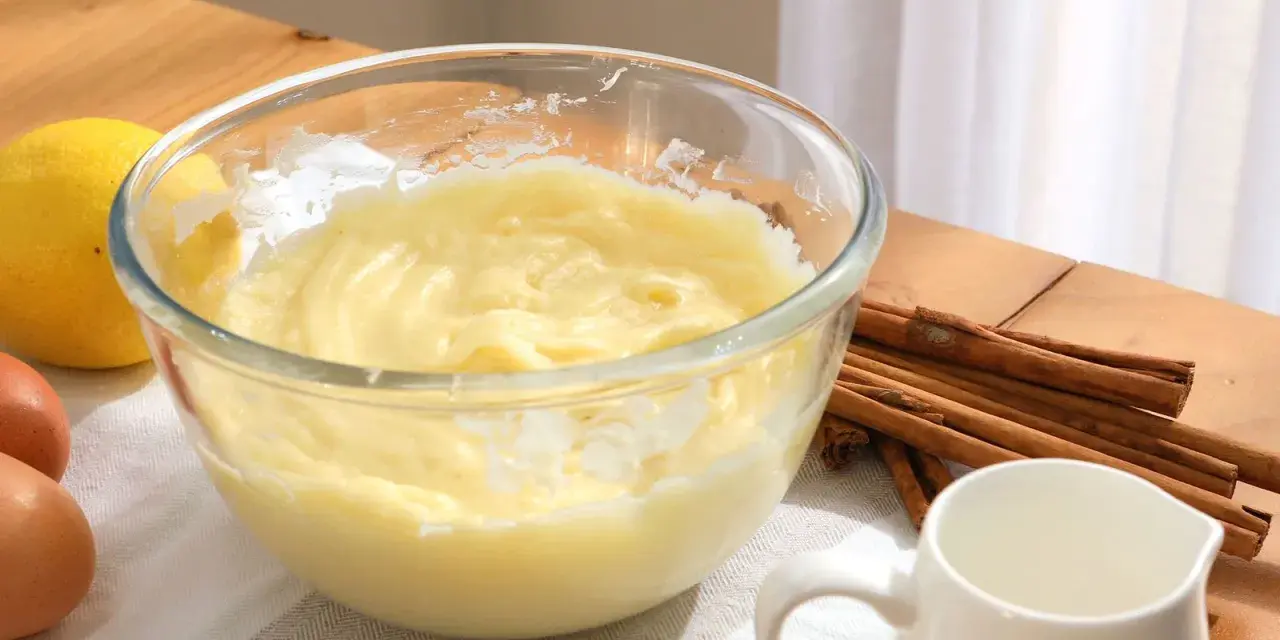 Bol con crema pastelera, huevos, limón y canela. Ingredientes para un postre delicioso.