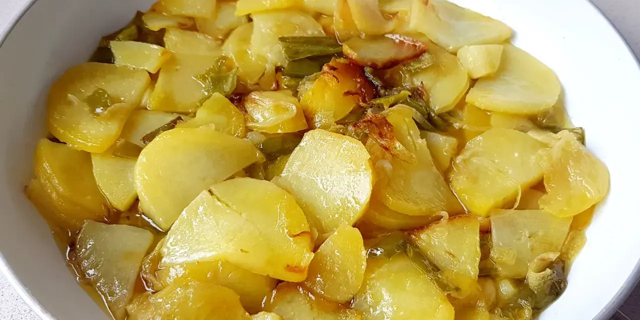 Patatas a lo pobre, un plato sencillo y delicioso, con patatas cortadas finas y tiernas, cocinadas con cebolla y pimientos verdes.