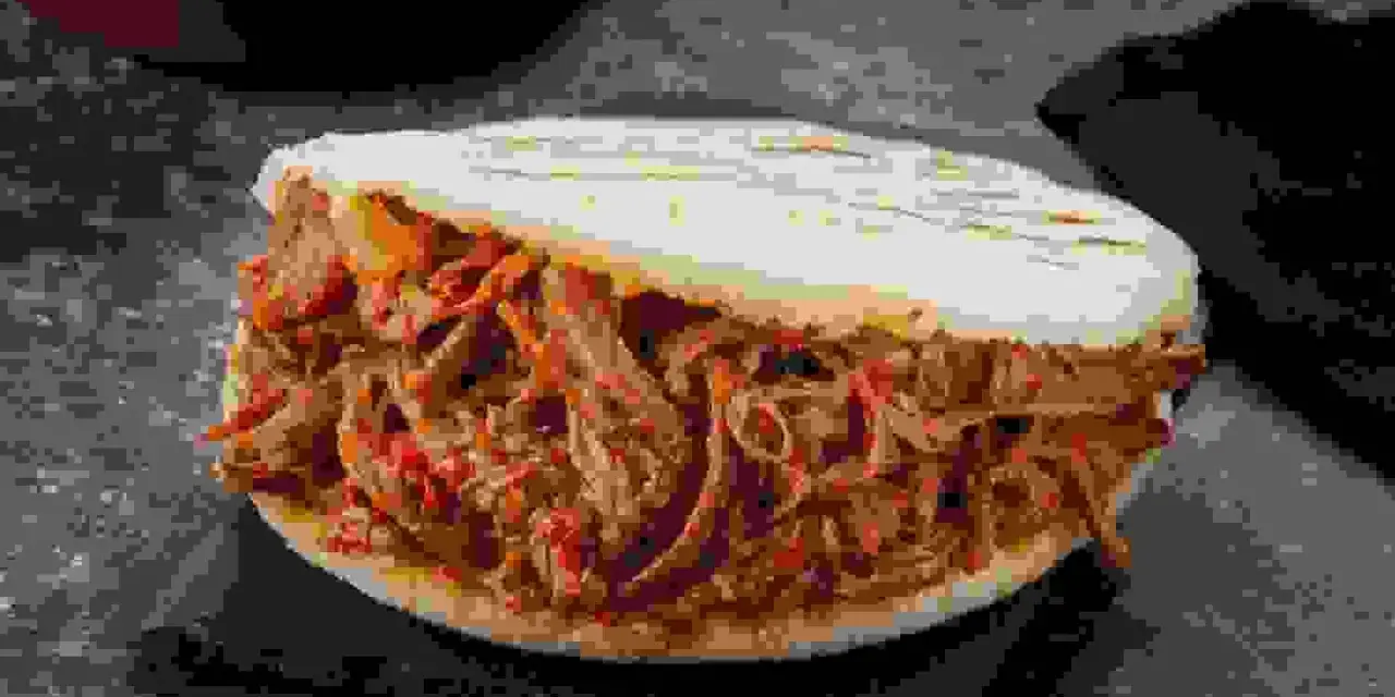 Arepa rellena de jugosa carne mechada, un clásico venezolano listo para disfrutar.