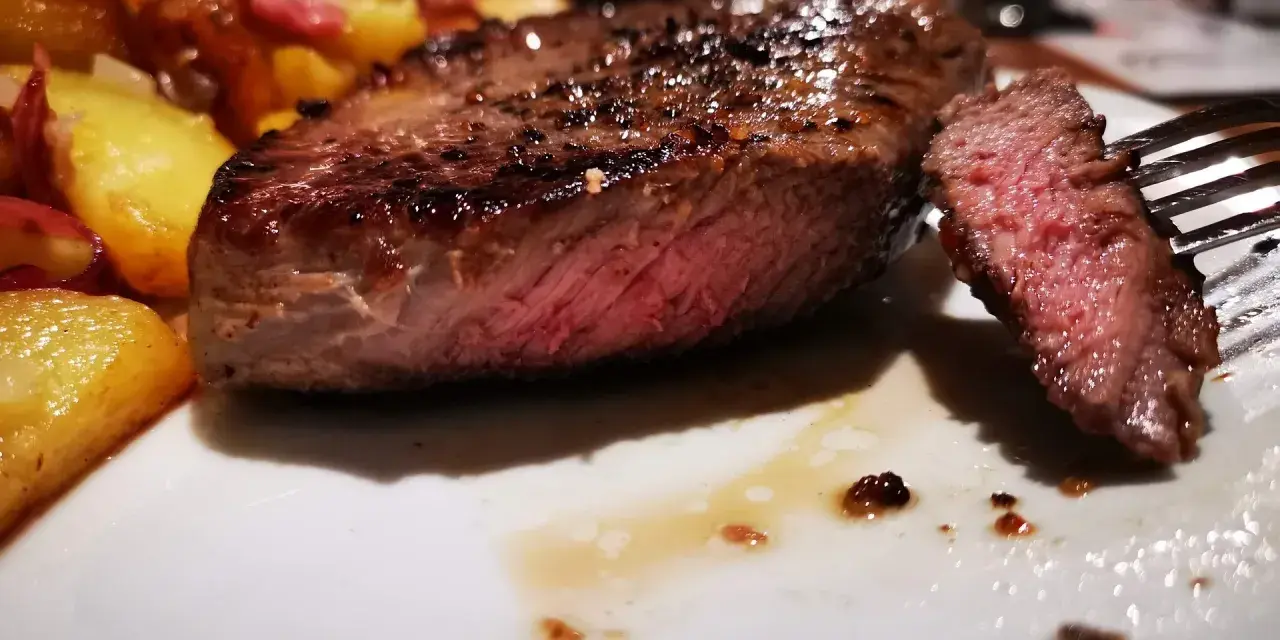 Un jugoso entrecot a la plancha, perfectamente cocinado, acompañado de patatas rústicas.