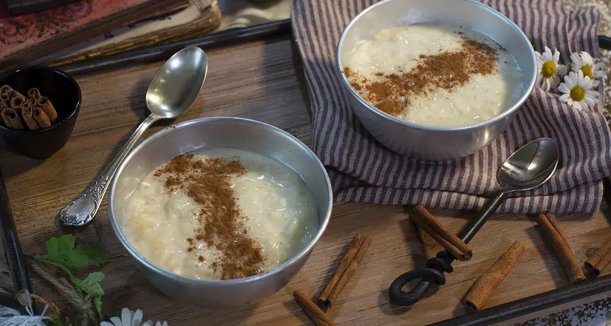 Dos cuencos de cremoso arroz con leche, espolvoreado con canela, listos para disfrutar. Un postre perfecto hecho con Thermomix.