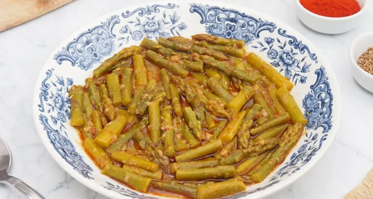 Espárragos esparragados en un plato con diseño azul y blanco, acompañados de pimentón y comino.