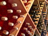 Estanterías de madera llenas de botellas de vino tinto y blanco. Un lugar donde se guarda el vino, listo para ser disfrutado.