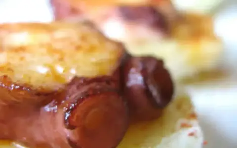 Tentáculos de pulpo a la plancha, dorados y jugosos, servidos sobre una base cremosa.