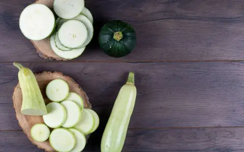 Rodajas de calabacín y calabacines enteros, listos para preparar deliciosas recetas con calabacín.