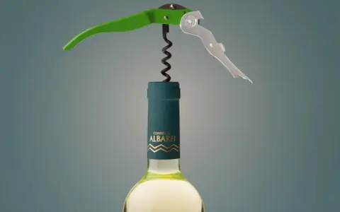 Sacacorchos verde y plateado sobre una botella de vino blanco "Condes de Albarei". El sacacorchos está listo para extraer el corcho, recordándonos de donde viene el corcho.