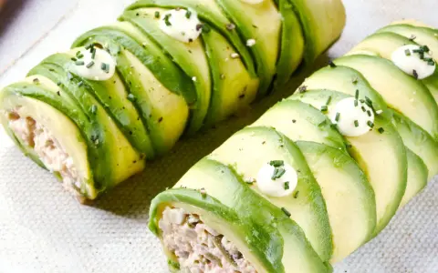 Rollos de aguacate rellenos, perfectos para recetas con aguacate. Decorados con puntos de crema y cebollino.
