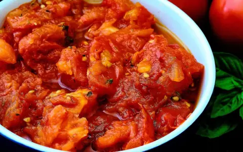 Un tazón de tomates picados, con un toque de albahaca y un aroma delicioso. Un bonito con tomate listo para disfrutar.