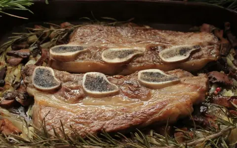 Ternera al horno jugosa, tierna y dorada, servida con champiñones, cebolla y romero fresco. ¡Un festín para los sentidos!