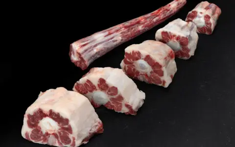 Trozo largo de carne de ternera para guisar y varias porciones cortadas en rodajas, listas para un estofado delicioso.