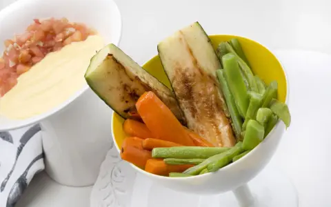 Deliciosas verduras a la plancha: calabacín, zanahoria y judías verdes, servidas con una salsa cremosa y pico de gallo.