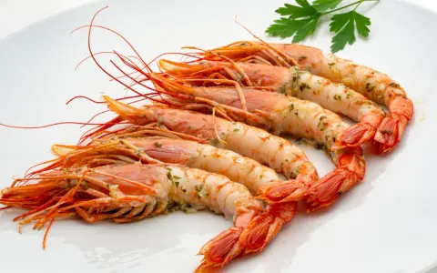 Gambones al horno, jugosos y con un toque de perejil, listos para disfrutar.