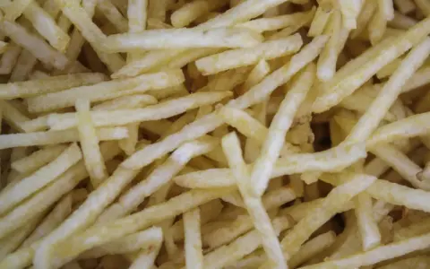 Un montón de patatas paja doradas y crujientes, listas para ser disfrutadas.