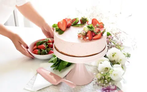 Deliciosa tarta de fresa decorada con fresas frescas y menta, lista para ser servida.