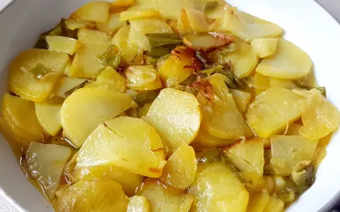 Patatas a lo pobre, un plato sencillo y delicioso, con patatas cortadas finas y tiernas, cocinadas con cebolla y pimientos verdes.