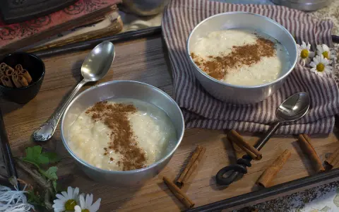 Dos cuencos de cremoso arroz con leche, espolvoreado con canela, listos para disfrutar. Un postre perfecto hecho con Thermomix.