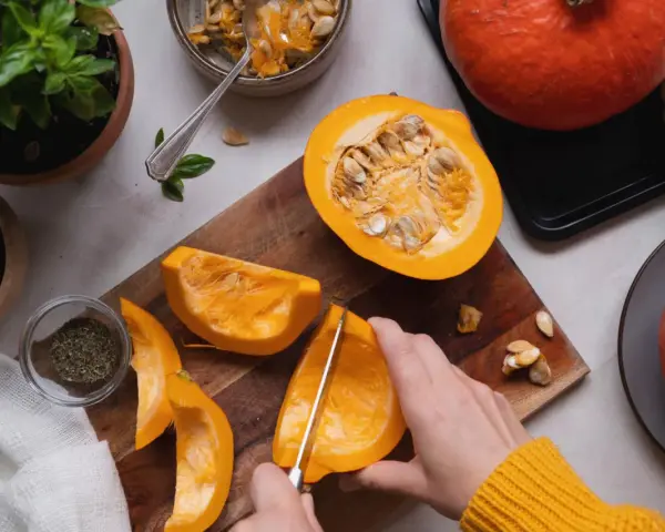 Manos cortando calabaza para deliciosas recetas. Ingredientes frescos listos para cocinar.