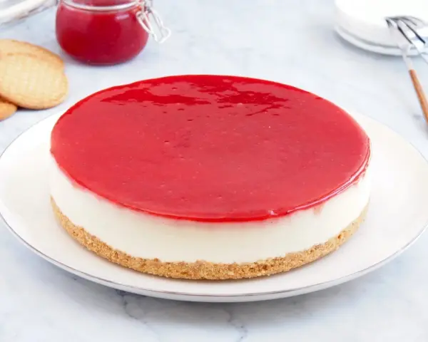 Deliciosa tarta de queso Philadelphia con cobertura roja brillante, lista para disfrutar.