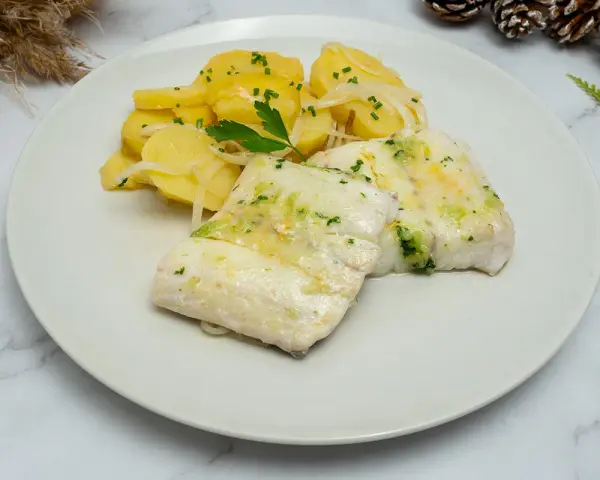 Deliciosa merluza al horno con patatas panadera y perejil picado. Un plato principal ligero y sabroso.