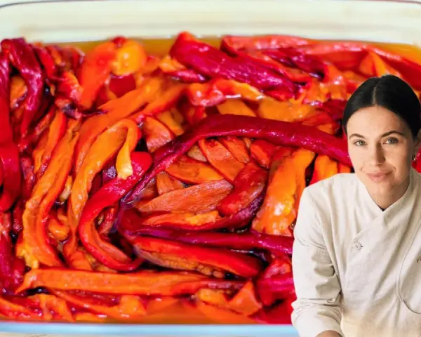 Pimientos asados en una bandeja de vidrio, listos para disfrutar. Una chef sonríe al fondo.