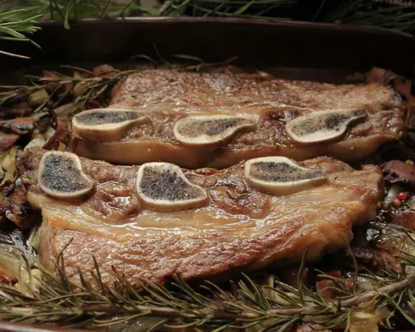 Ternera al horno jugosa, tierna y dorada, servida con champiñones, cebolla y romero fresco. ¡Un festín para los sentidos!